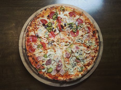 Close-up of a delicious pepperoni and salami pizza on a wooden table, featuring mushrooms and jalapenos.