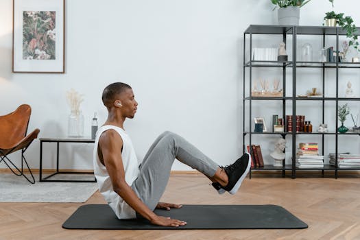 An African American man practicing yoga indoors on a mat, emphasizing fitness.