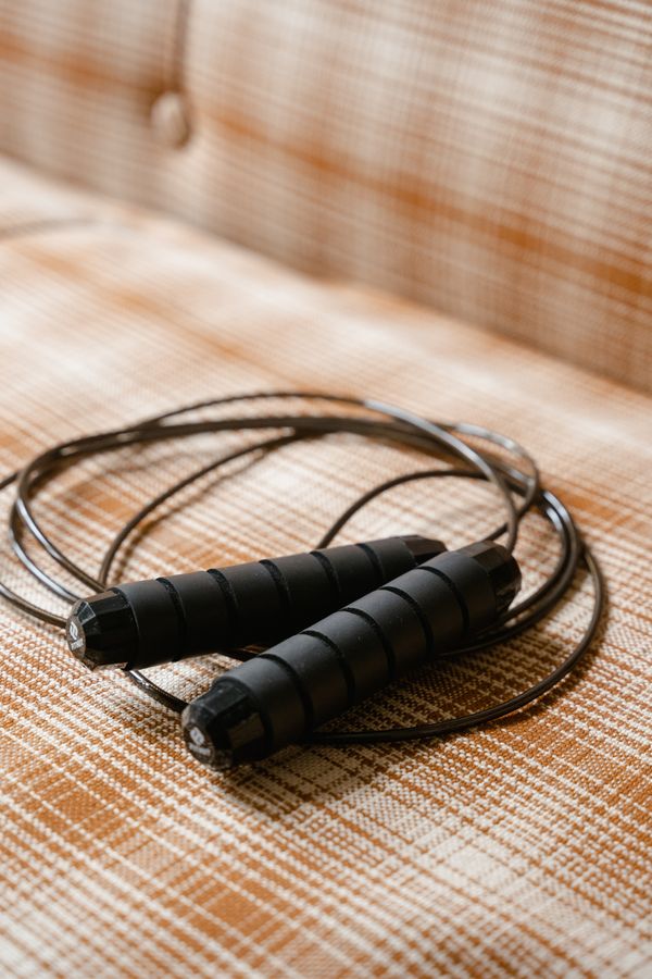 Coiled skipping rope resting on a woven surface — photo by MART PRODUCTION on Pexels