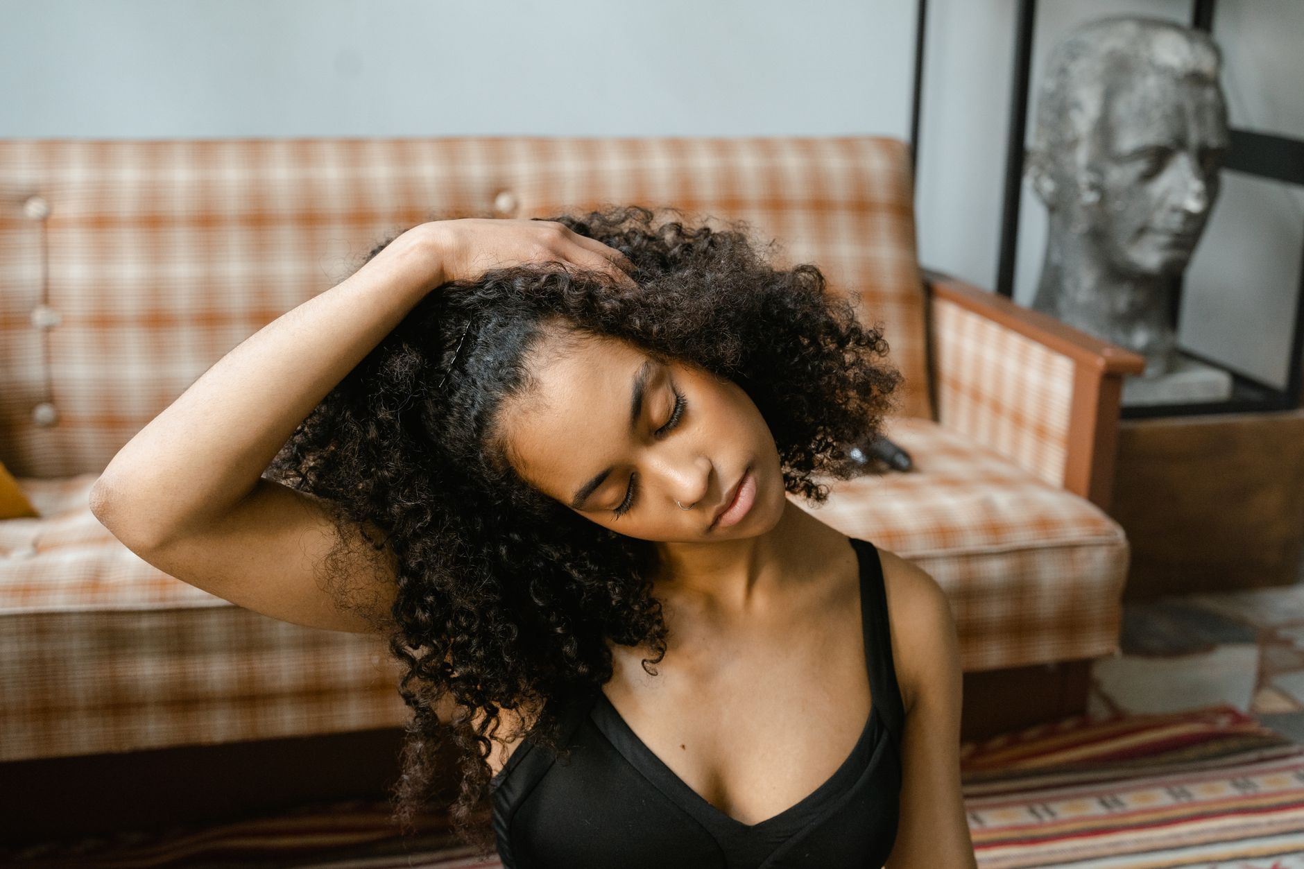 A serene portrait of a young woman in a yoga pose, promoting a healthy lifestyle indoors.