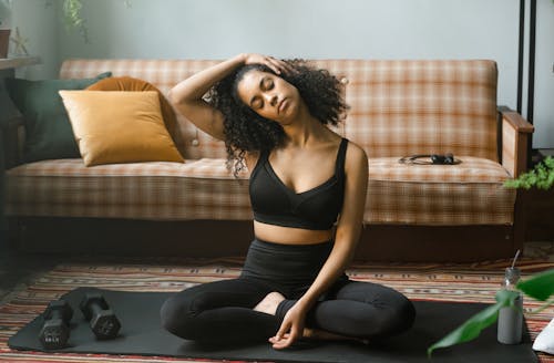 Free A Woman Stretching on a Yoga Mat  Stock Photo