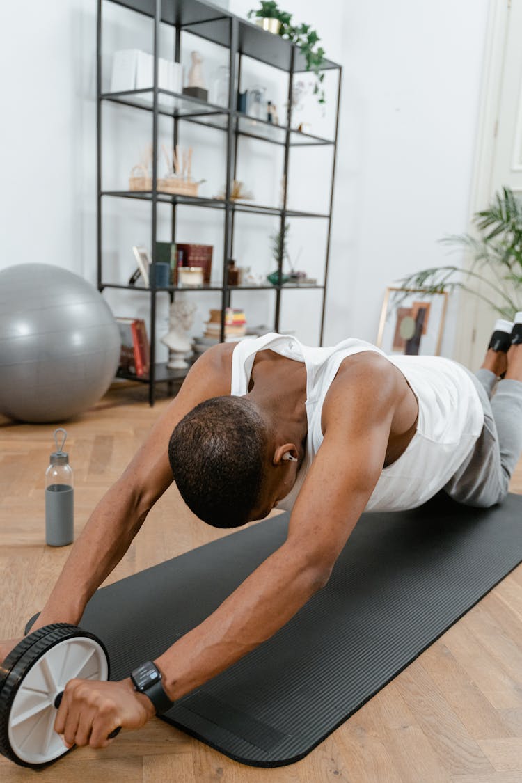 A Man Working Out Using An Ab Roller 