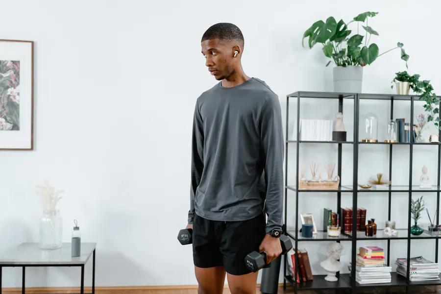 person training with dumbbells in a home gym setup