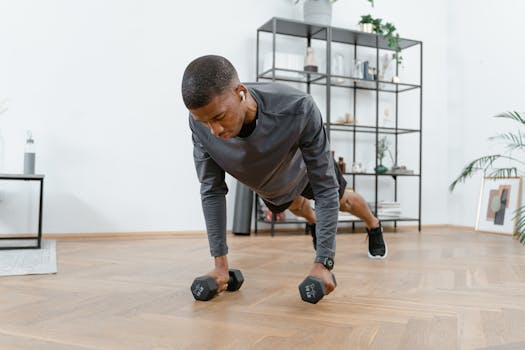 A man performing push-ups with dumbbells in a modern living room setting.