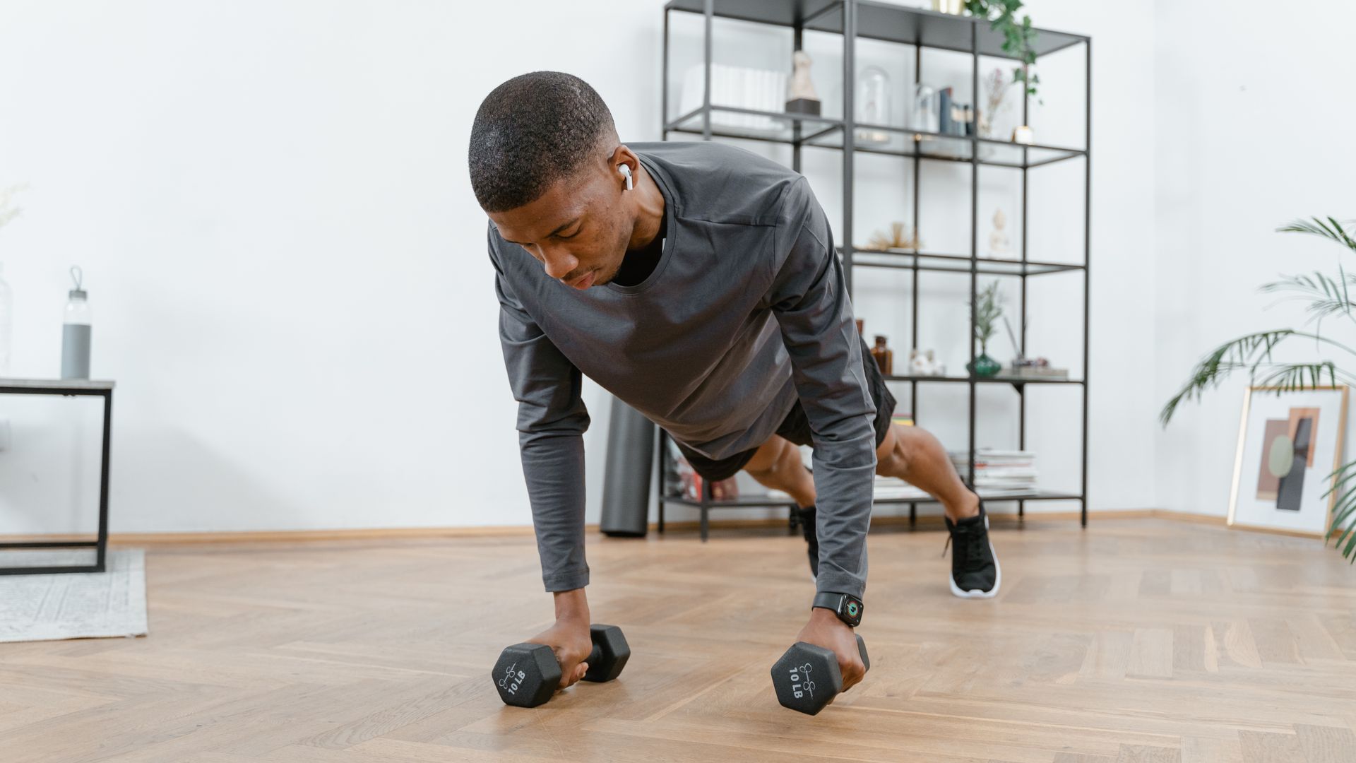 Exercise Unlocking for Beginners: Your Comprehensive Guide A man performing push-ups with dumbbells in a modern living room setting — exercise unlocking for beginners