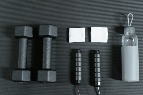 Free Flat lay of dumbbells, jump rope, and other gym essentials for a healthy lifestyle. Stock Photo
