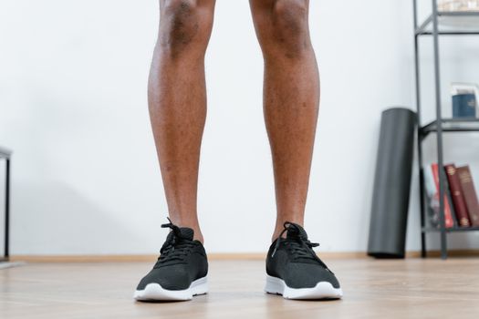 Detailed shot of black running shoes on a wooden floor, perfect for fitness and workout themes.