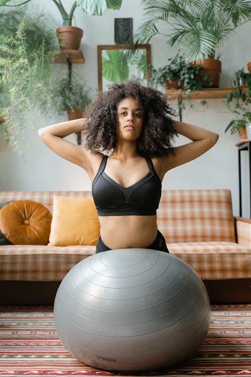 Pretty Woman in Black Sports Bra Using an Exercise Ball · Free Stock Photo