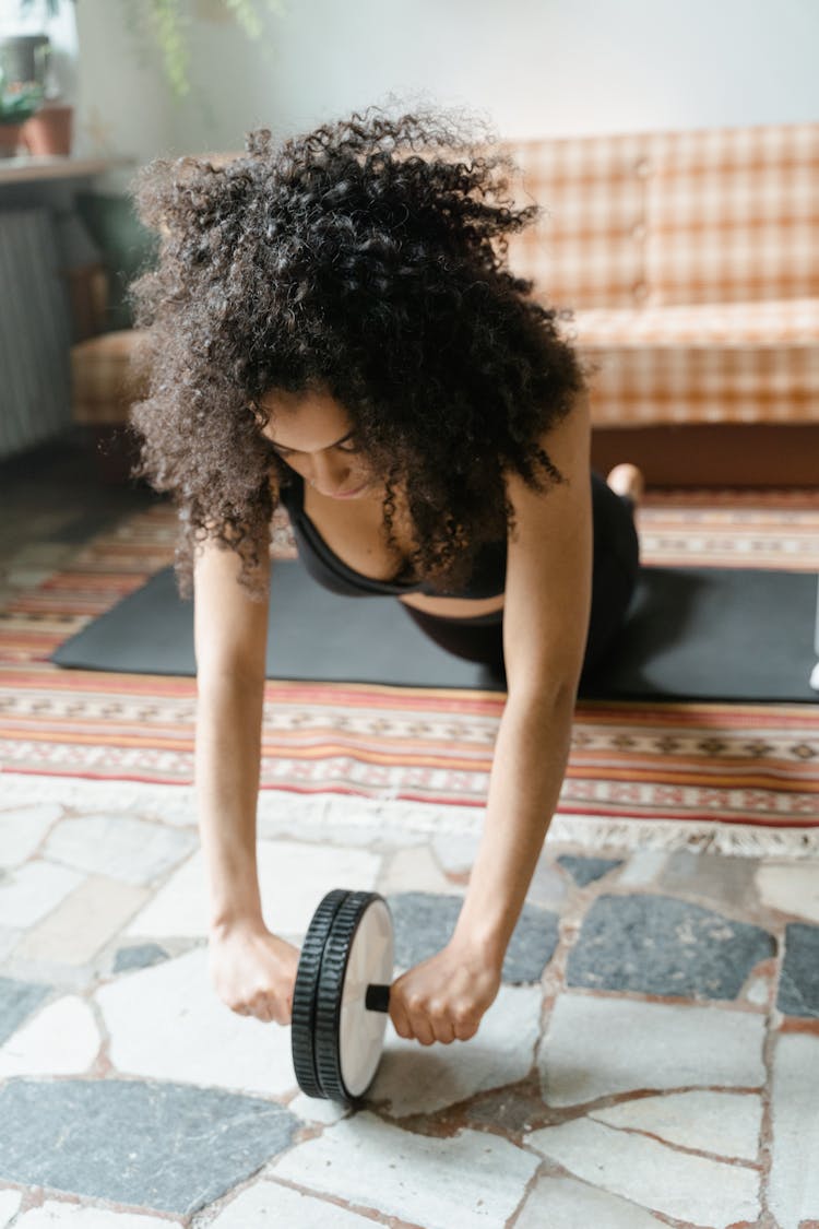 A Woman Using An Ab Roller 