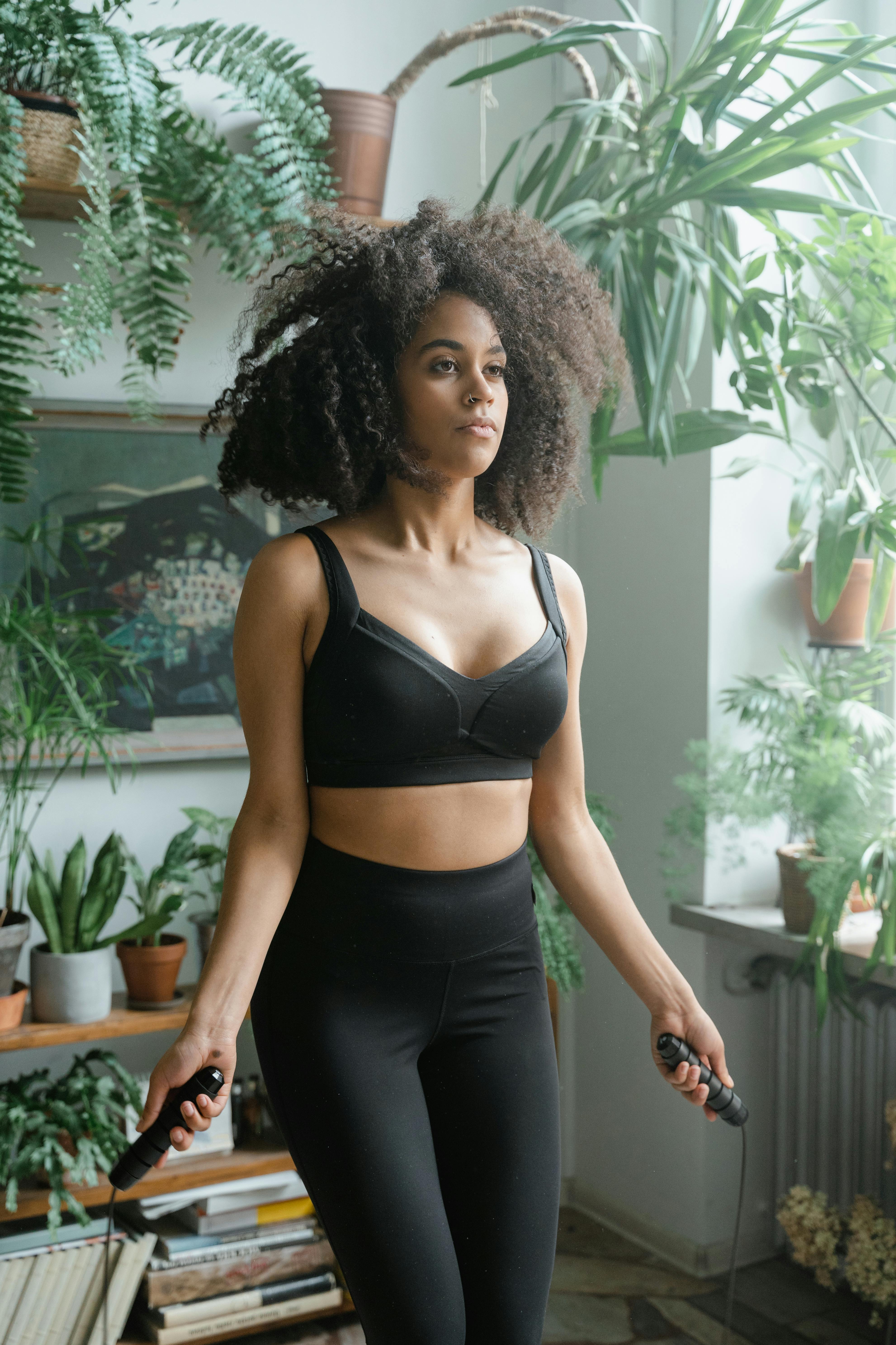Foto de Athletic African American black female wearing workout clothing.  Her sporty outfit is a sports bra and form fitting spandex shorts. She  looks strong and confident. do Stock