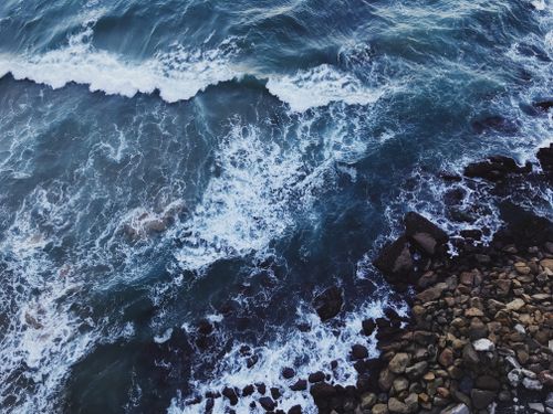 Free Aerial shot of waves crashing against rocks on Wollongong coastline, NSW, Australia. Stock Photo