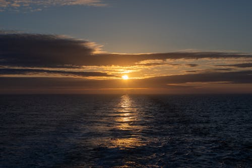 Free Sun Setting Over the Ocean Stock Photo