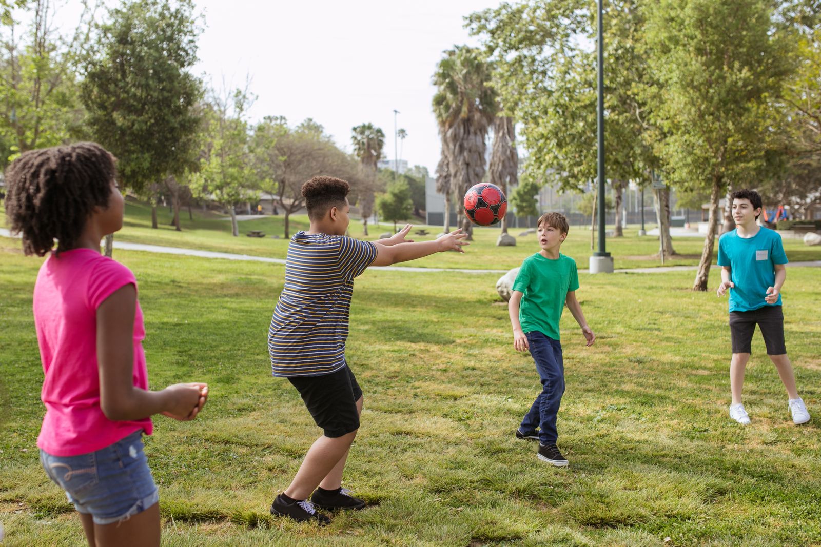 Juniors playing football in the park