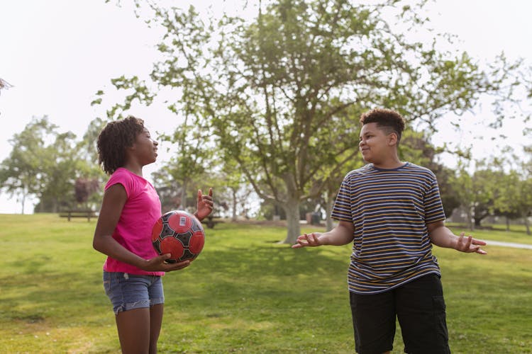 Teenagers Having Fun Playing Soccer Ball On A Park