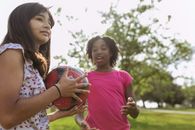 Girl in Pink Shirt Holding Soccer Ball