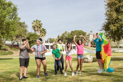 Free A group of happy children having fun flying a kite in a sunny park, enjoying friendship outdoors. Stock Photo