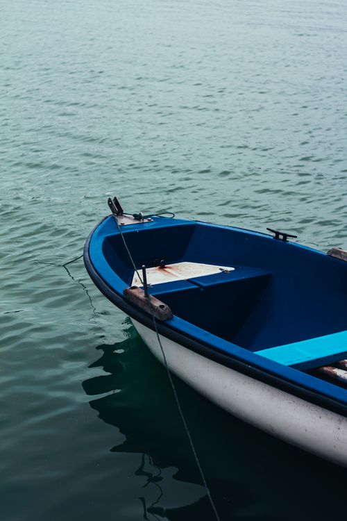Free A serene image of a blue rowboat floating on the tranquil sea in Algeria, showcasing peacefulness. Stock Photo