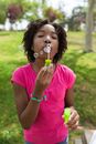 Close-Up Shot of a Girl in Pink Shirt Blowing Bubbles