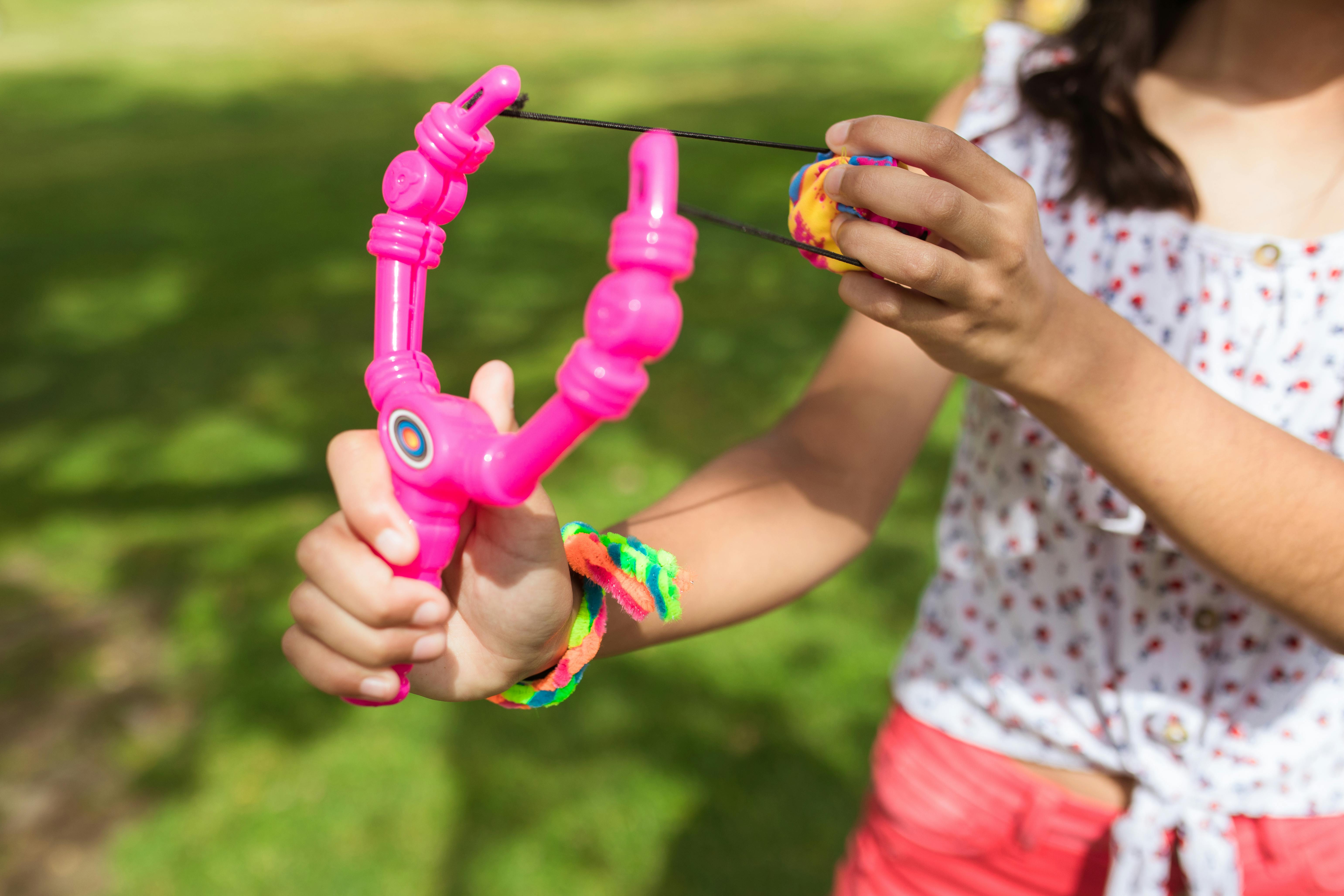 girl holding green and purple plastic toy