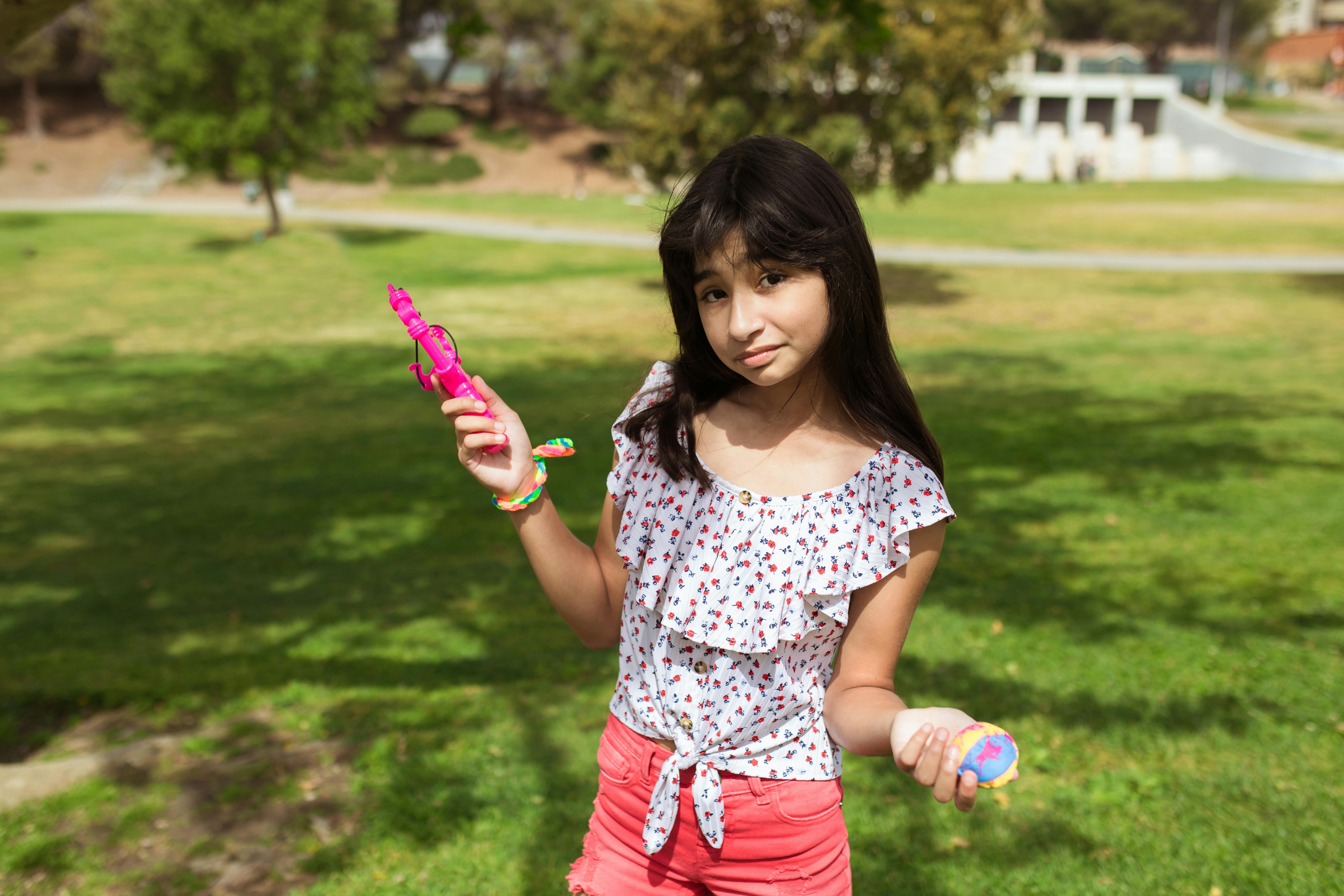 a pretty girl holding plastic toys while posing at the camera