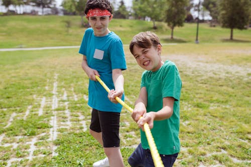 Free Close-Up Shot of Boys Playing Tug of War on Grass Stock Photo