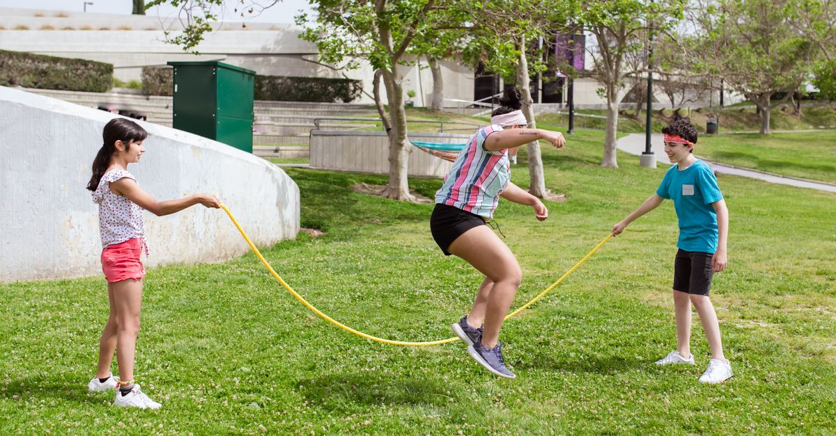 friends competing in backyard rock skipping competition