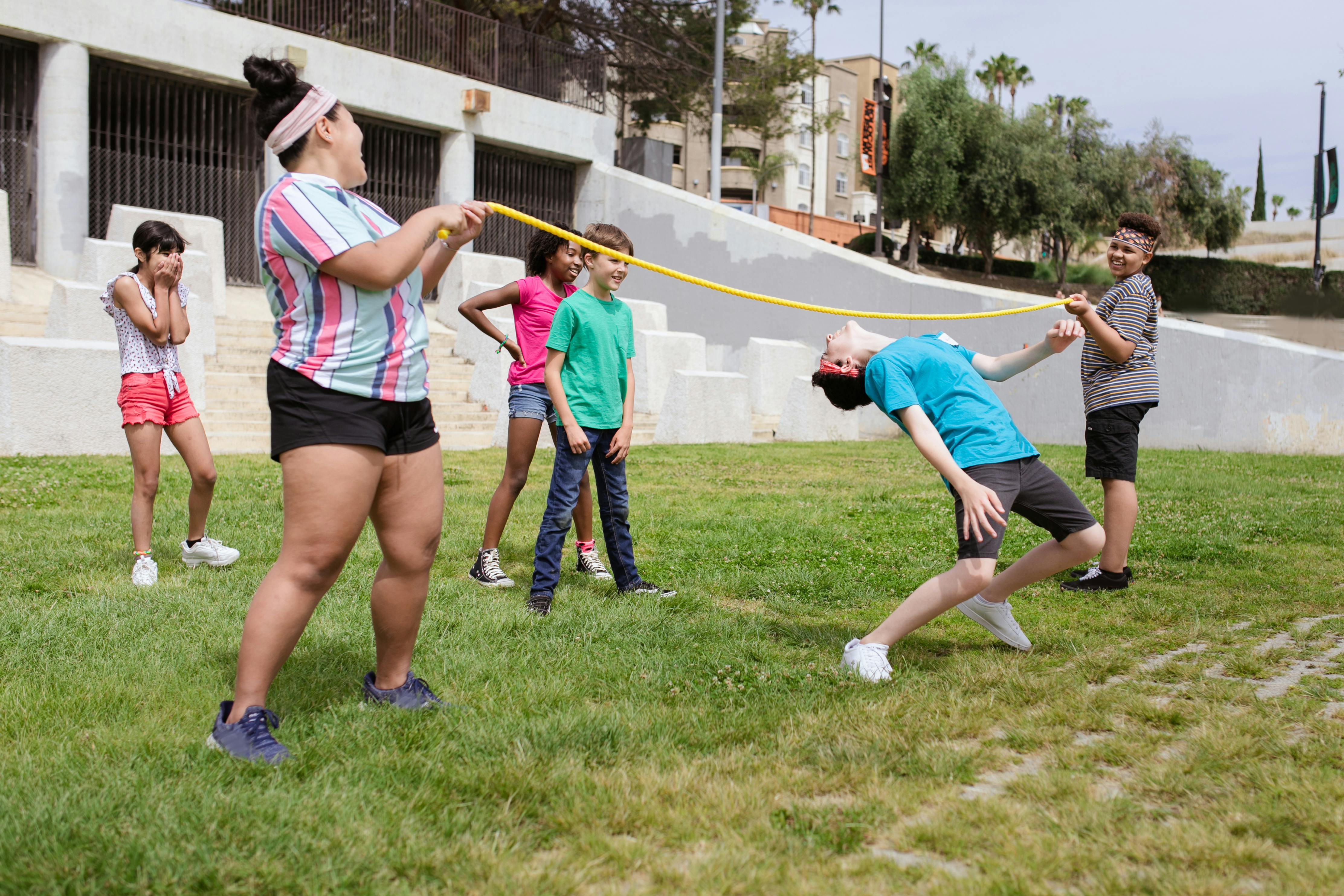 a boy bending her body under the rope