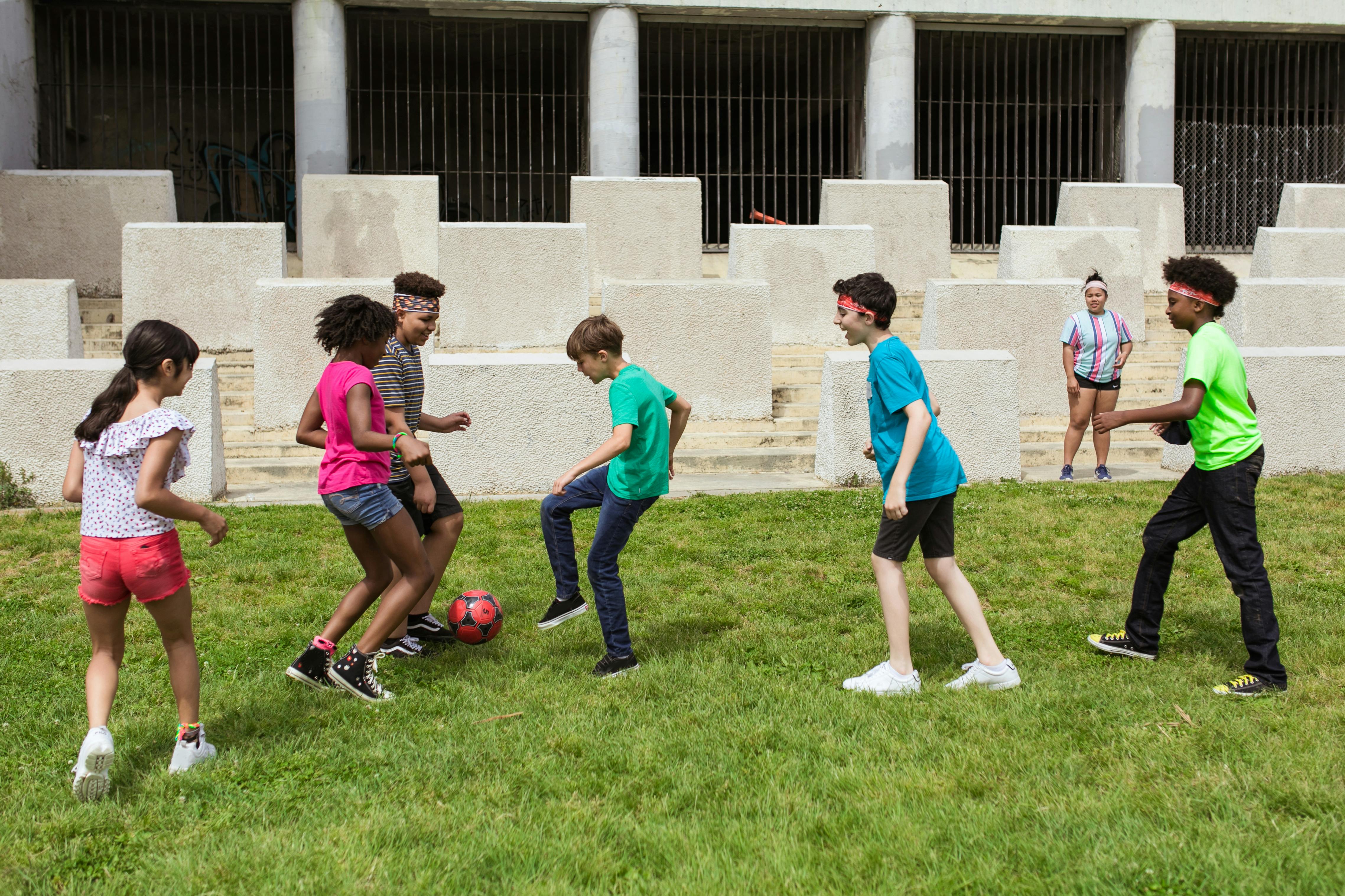 children playing soccer on green grass field