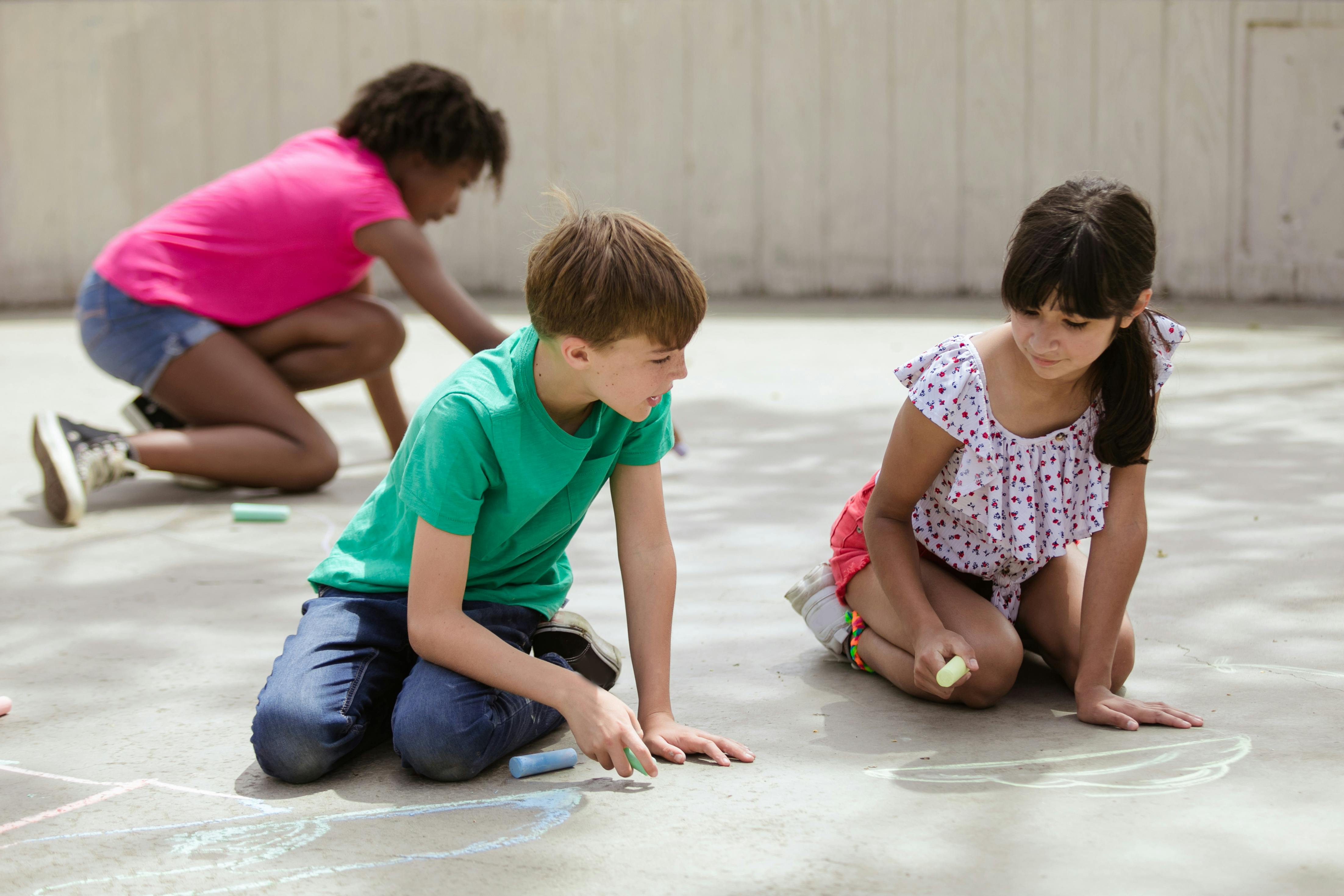 children writing on concrete floor