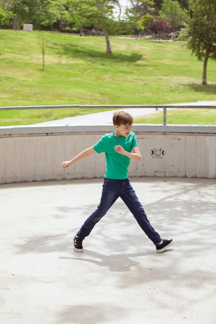 A Boy In Green Shirt Walking At The Park