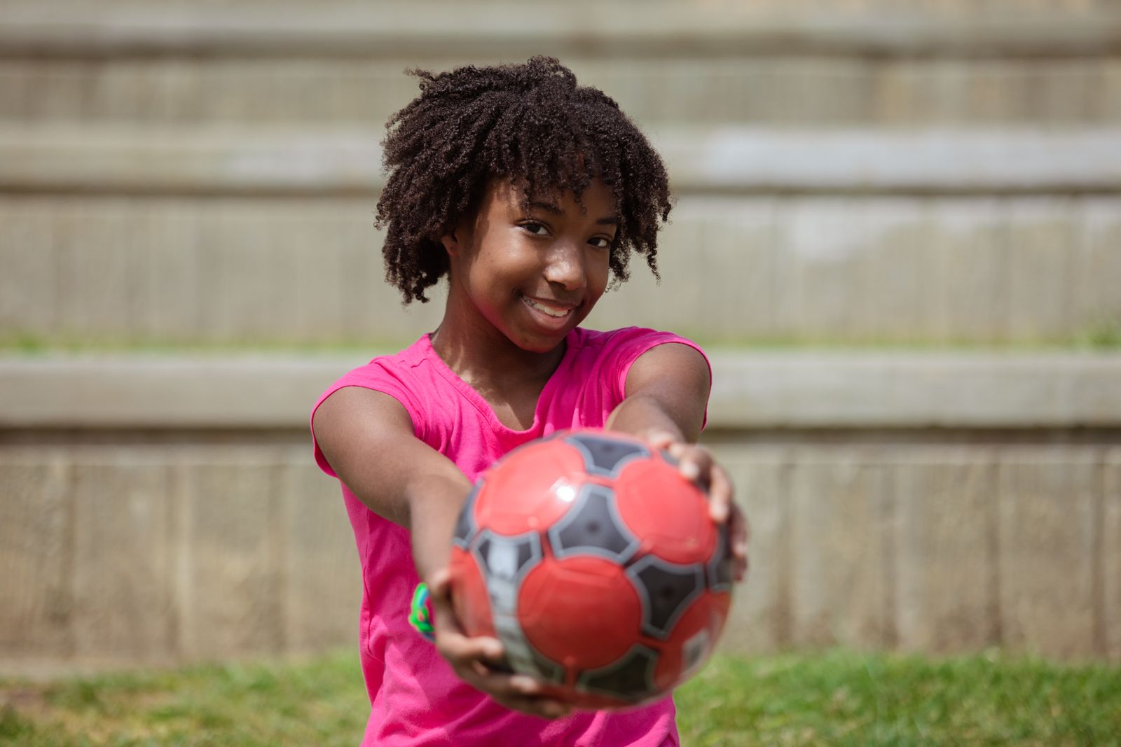 A joyful young player holding a soccer ball