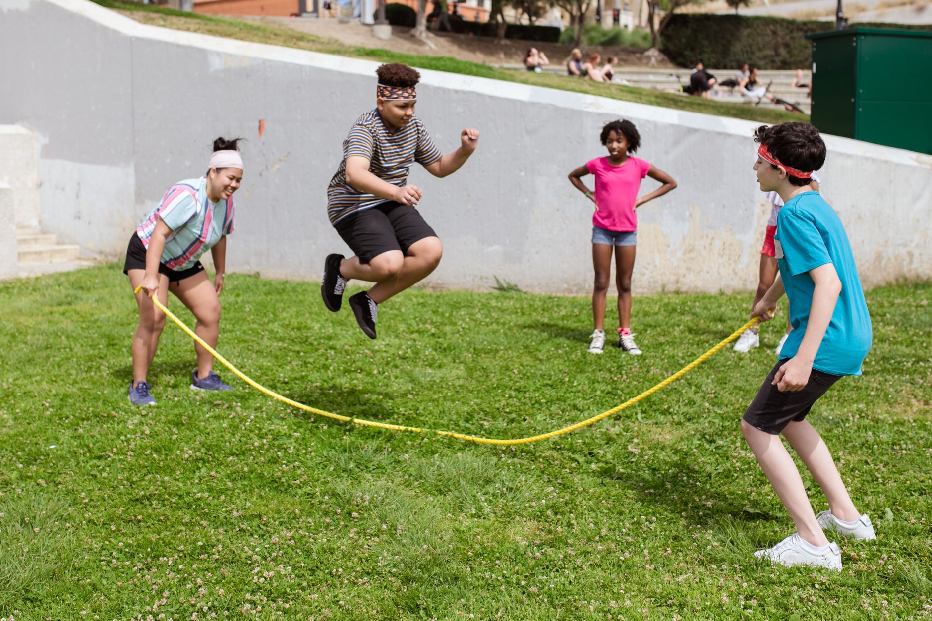 Children enjoying a fun and active day outdoors, playing jump rope together.