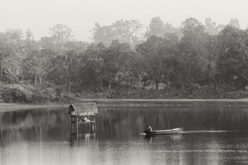 Free Serene black-and-white image of a boat on a peaceful lake in India, showcasing nature's beauty. Stock Photo