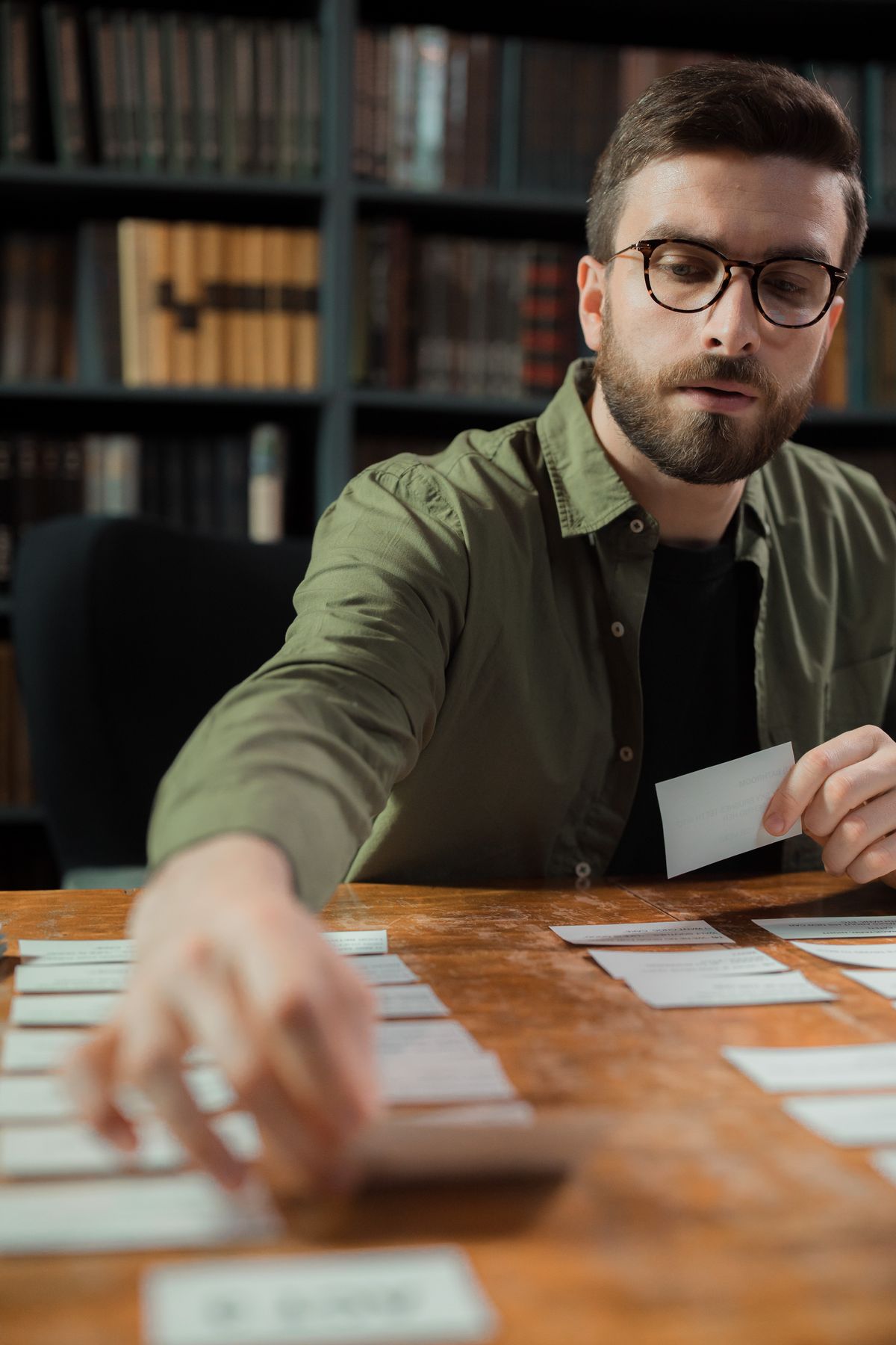 Engineering student sorting flashcards on a library table for active recall