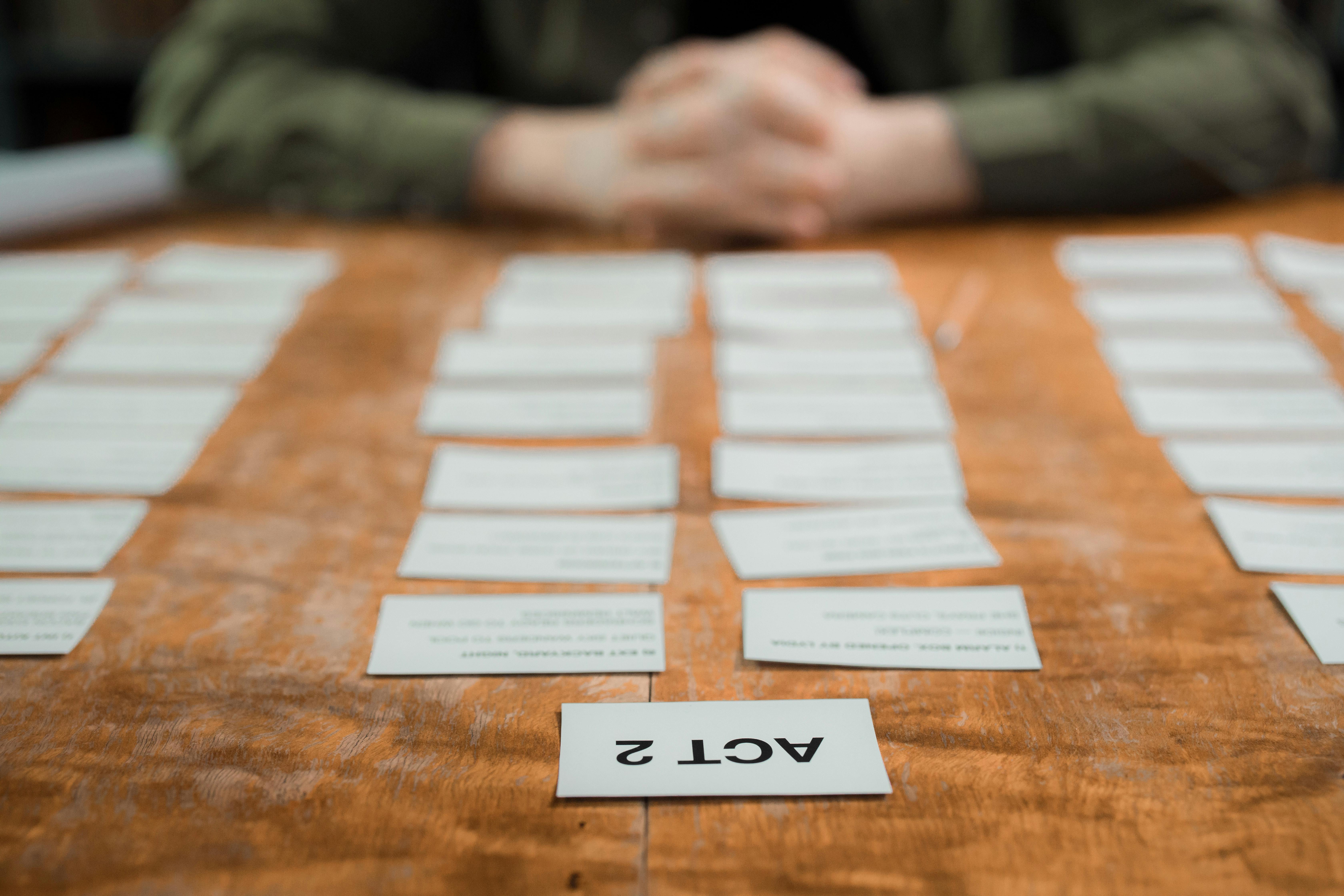 close up of cards with text of acts of a play on a table