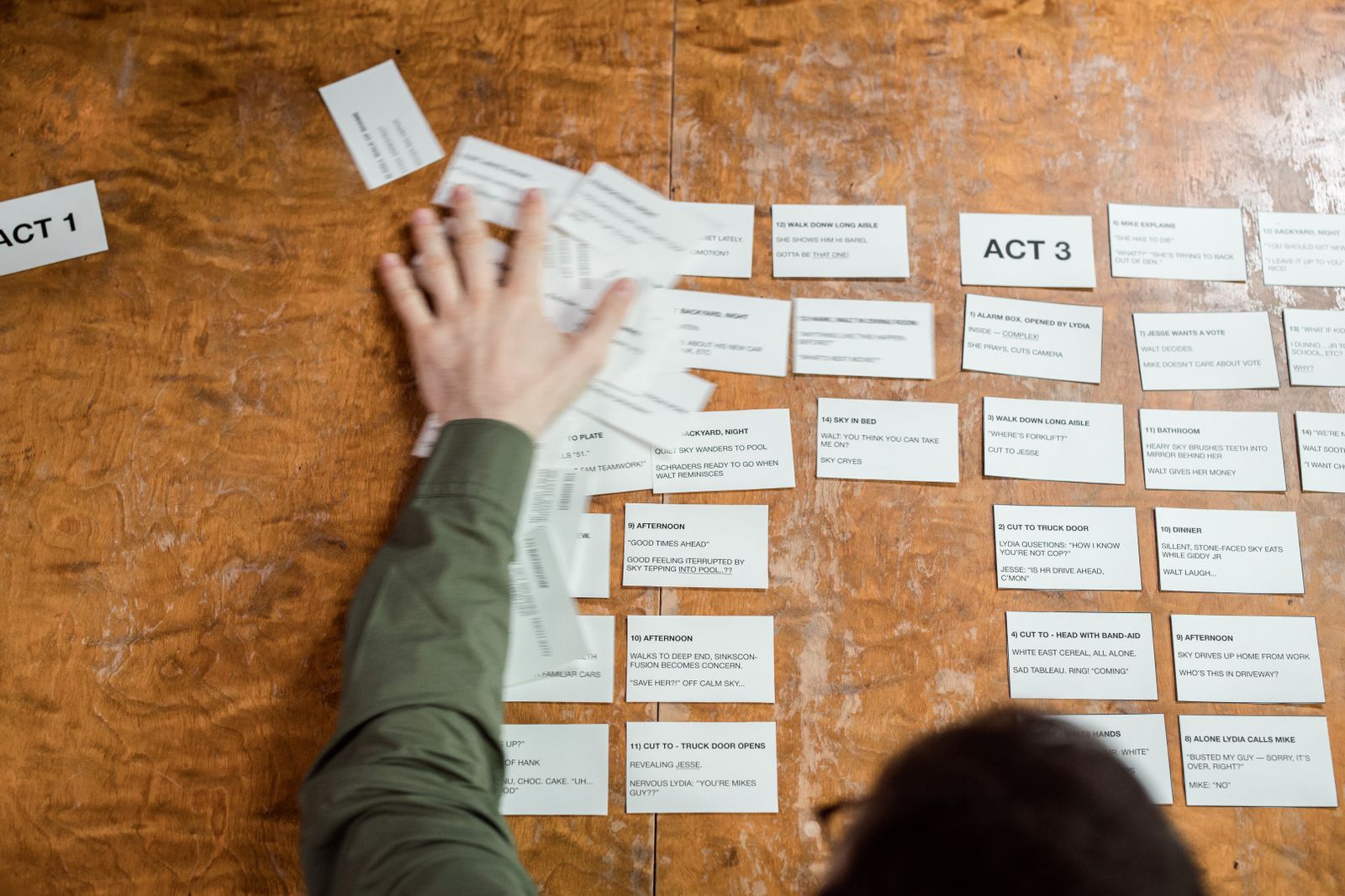 Hands arranging story cards for commercial concept planning