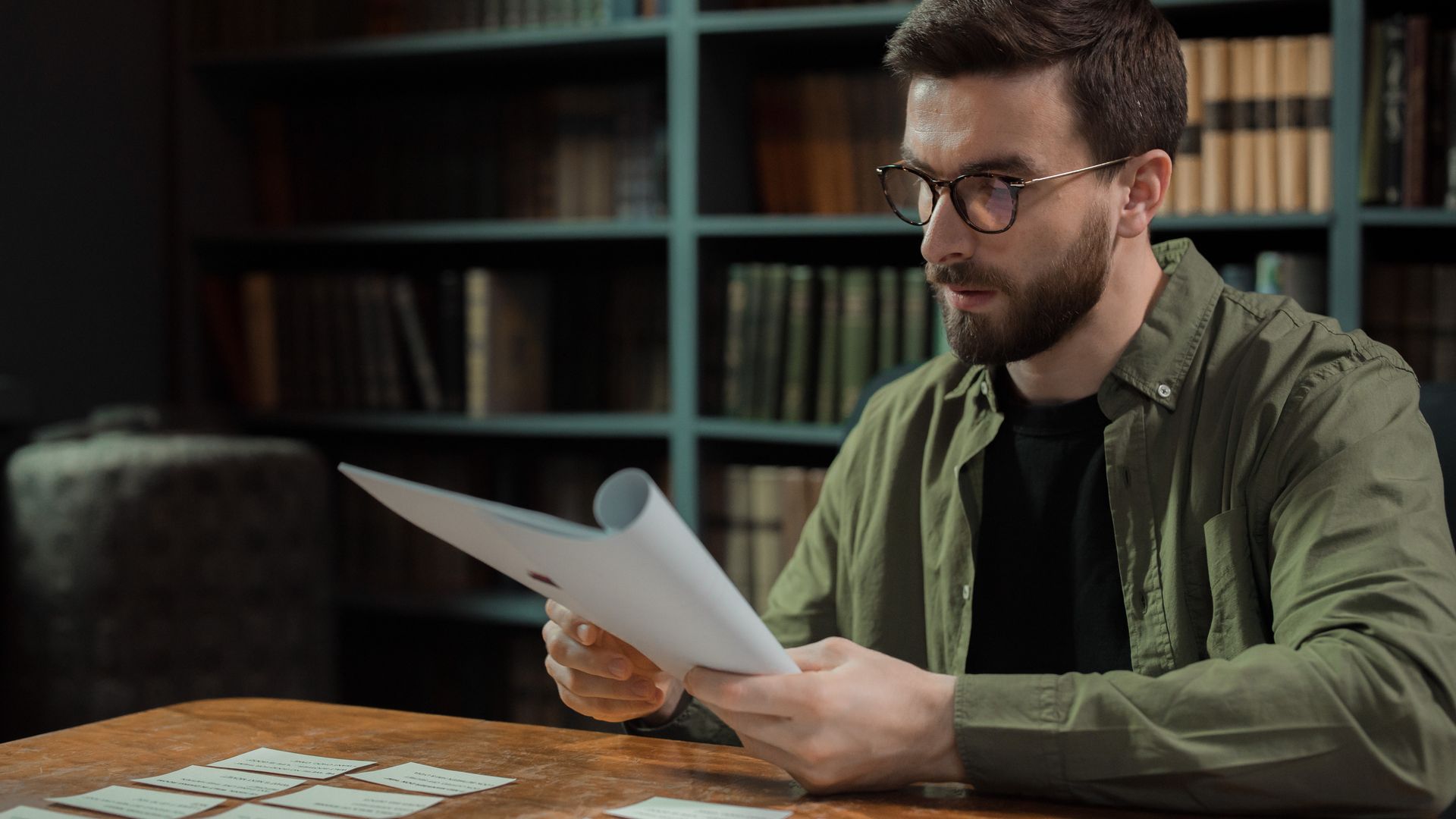 Modafinil Concentration: Boost Your Focus and Productivity A focused man with glasses carefully reviews documents at a library desk — modafinil concentration