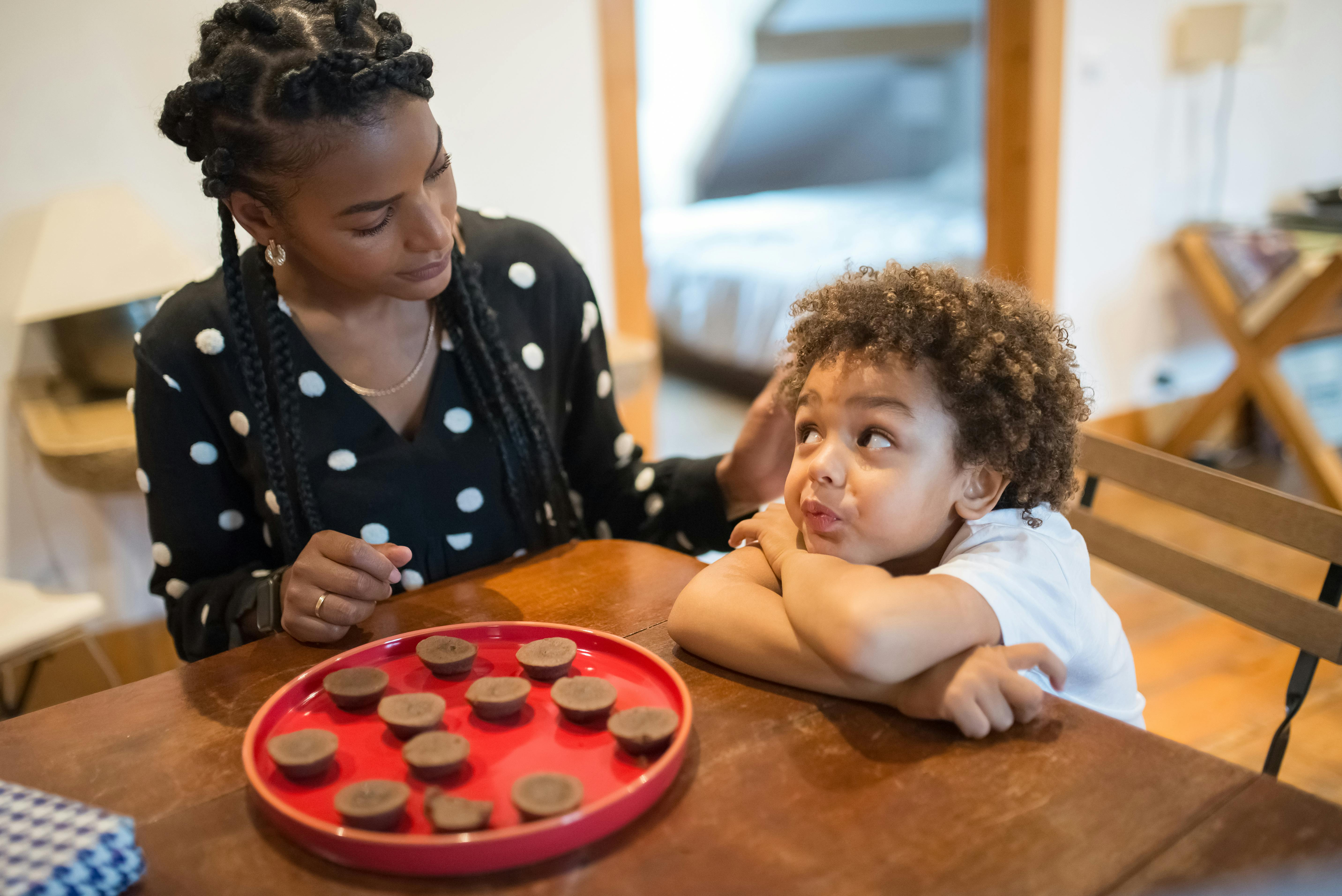 a boy sitting at table with his mother