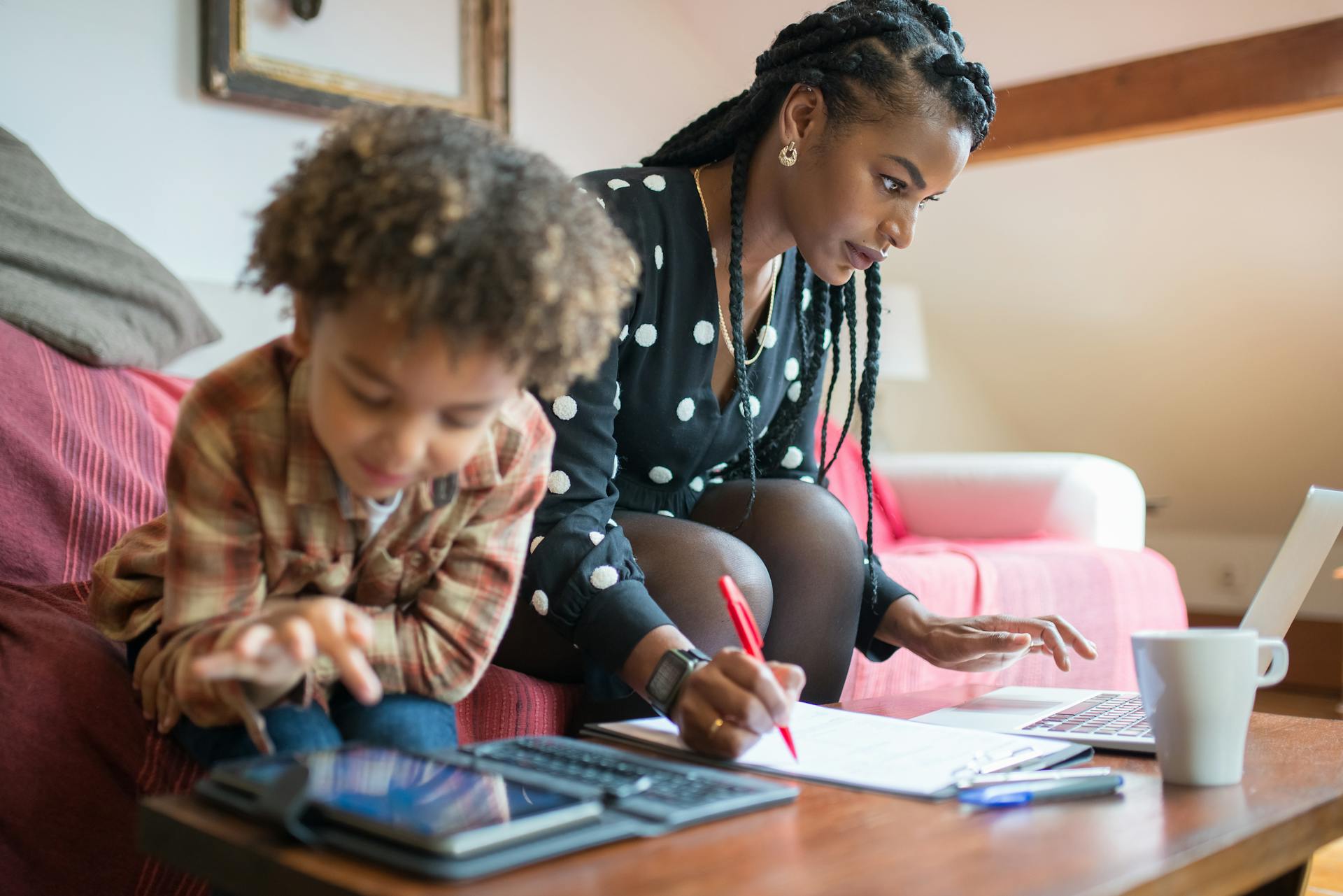 Mother Working on Laptop and Little Child Playing on Tablet