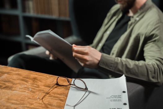 Man Sitting in Chair Reading Paperwork