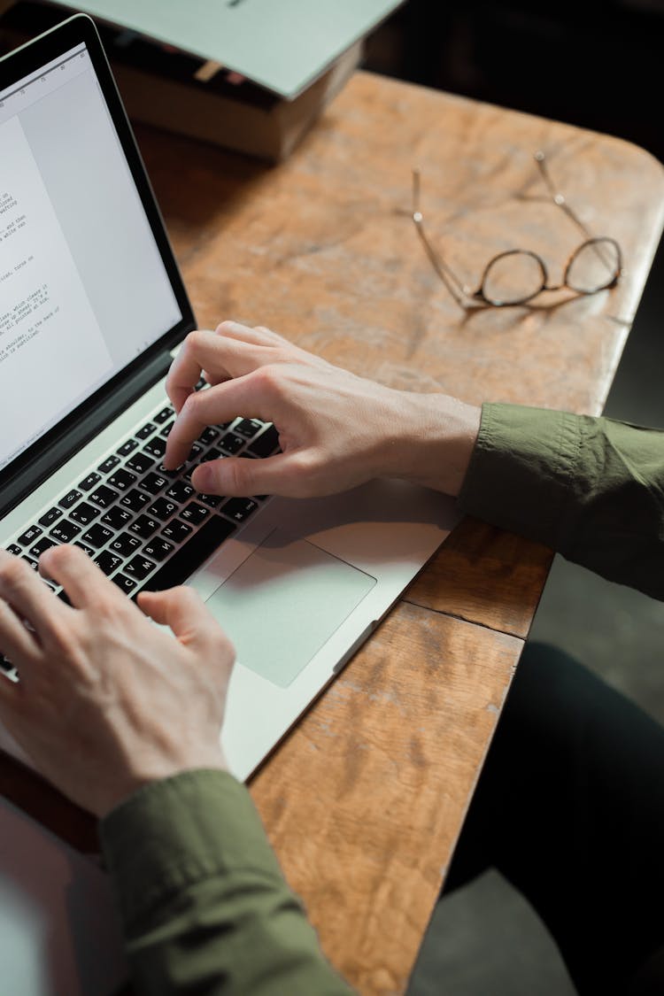 A Person Typing On A Laptop 