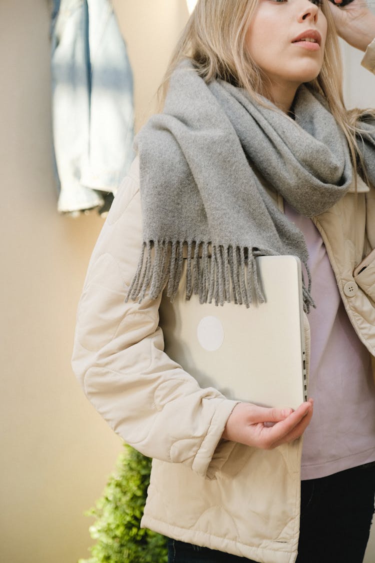 Woman In Gray Scarf Holding A Laptop