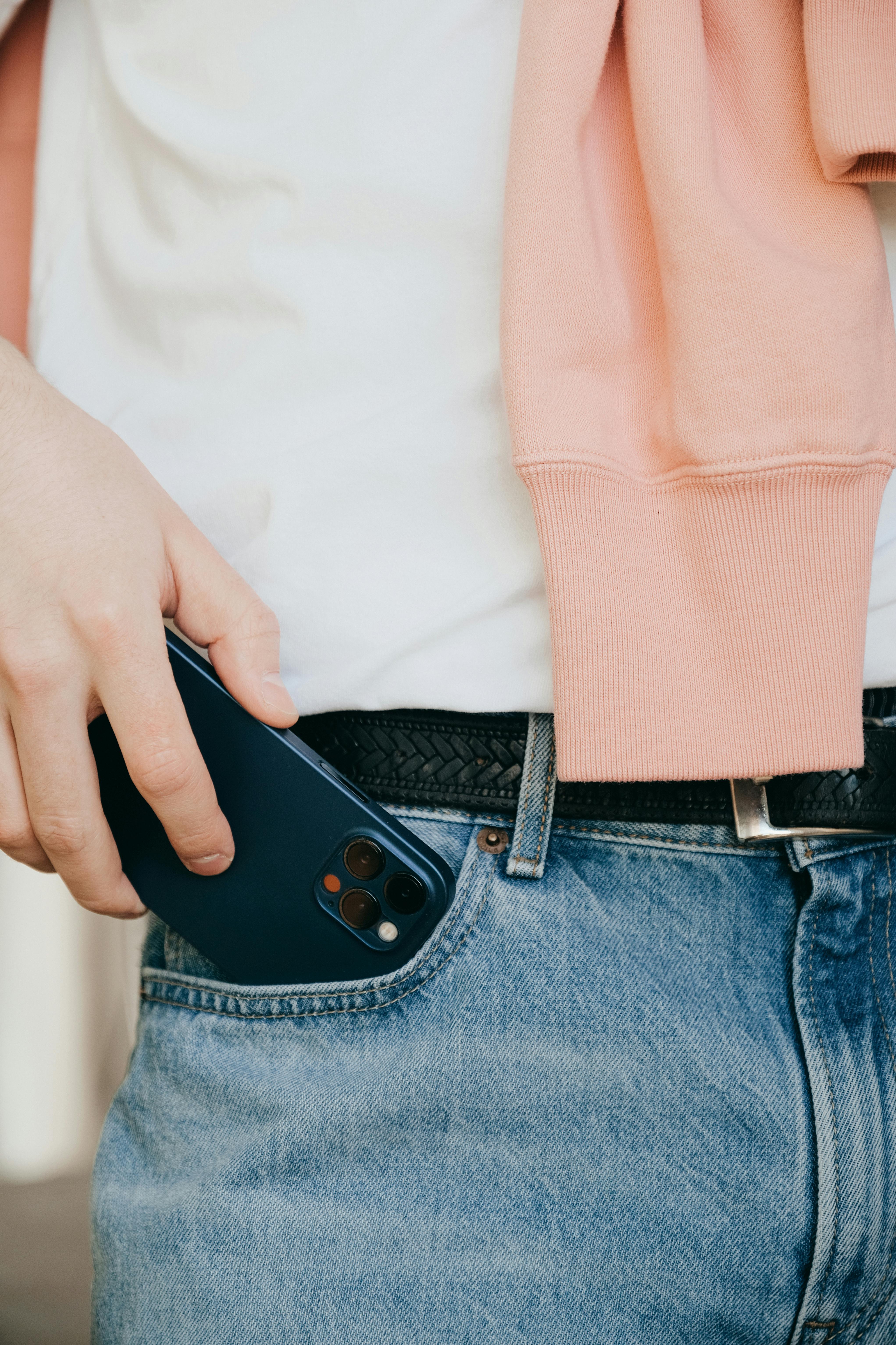 person putting phone on his pocket