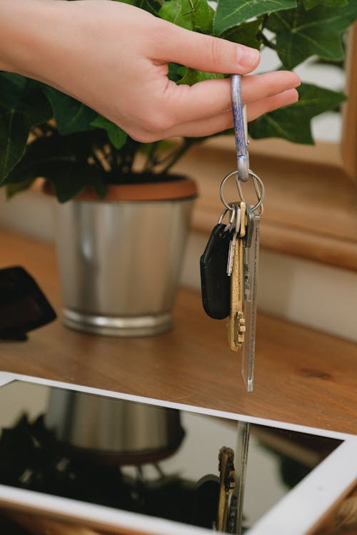 Close-Up Photo of Keys Hanging on a Person's Finger