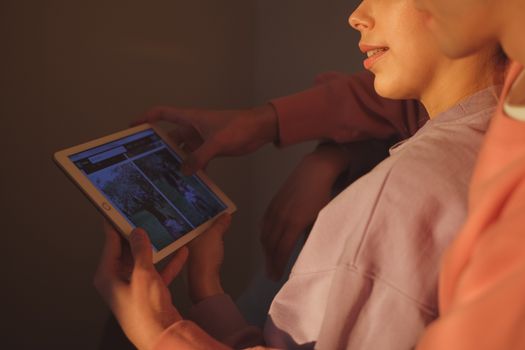 A couple using a tablet together in a cozy indoor setting, enjoying technology.