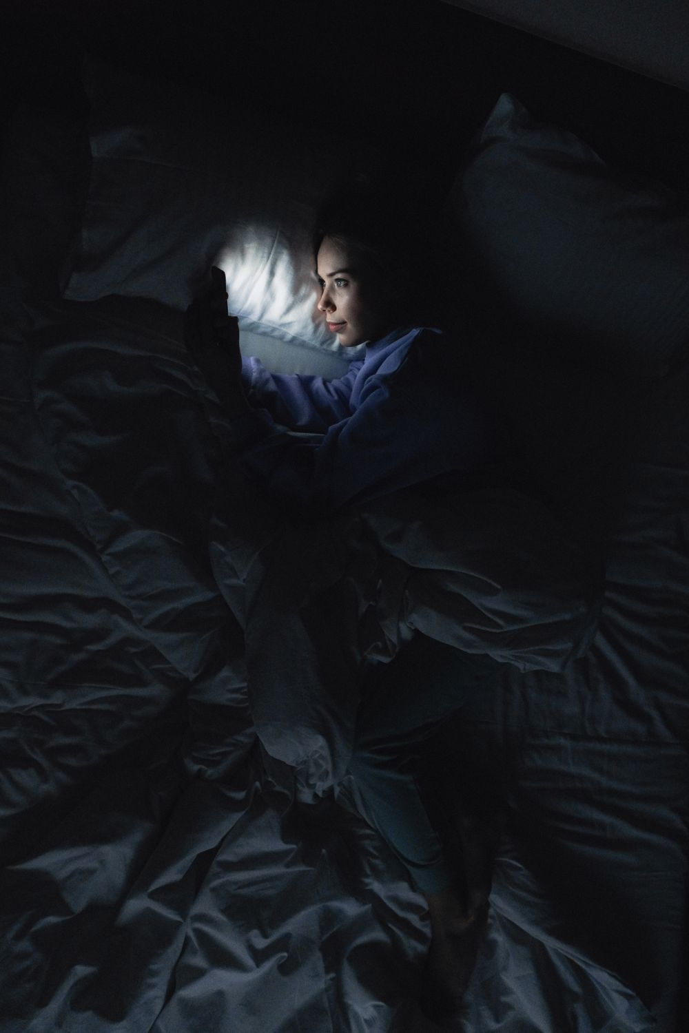 Person awake in bed using a phone at night