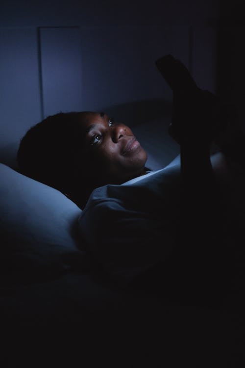 Free Woman Using a Cellphone during Bedtime Stock Photo