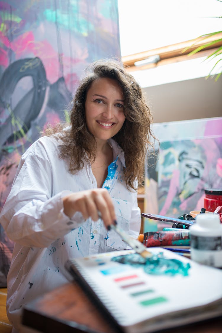 Portrait Of Smiling Artist Painting In Studio