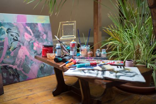 Free A vivid art studio setting showcasing diverse painting supplies and a colorful canvas. Stock Photo