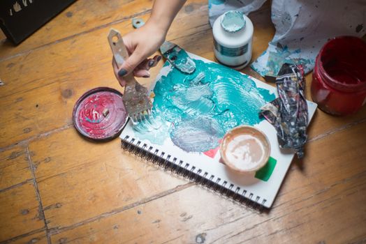 A hand painting with bold colors on a sketchbook, showcasing artistic creativity.